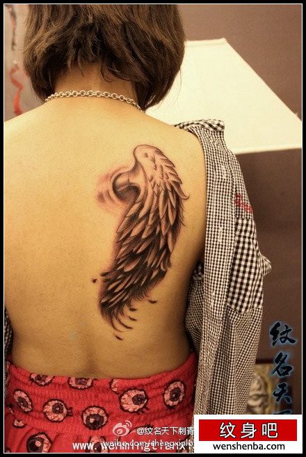 女人背部精致的翅膀纹身